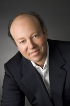 A man in a suit and tie sitting down.